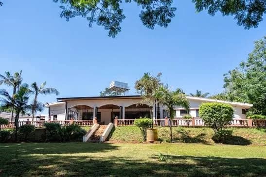 Chez Mahmadi in Kitisuru — a single-storey house with an arched veranda, set back across a lawn under palms